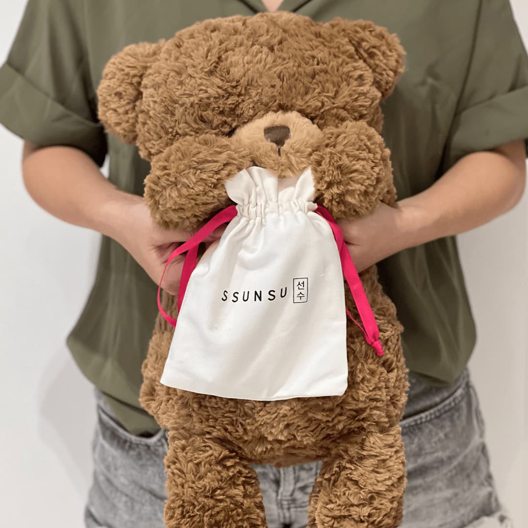 Ssunsu's Stay Healthy and Glowy Travel Kit being gifted by a teddy bear