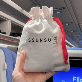Ssunsu's Stay Healthy and Glowy Travel Kit held in hand, on an airplane