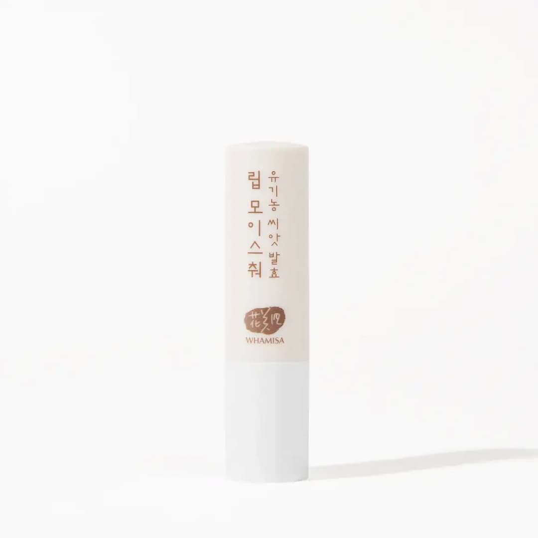 A single stick of Whamisa Organic Seeds Lip Balm standing upright against a white background